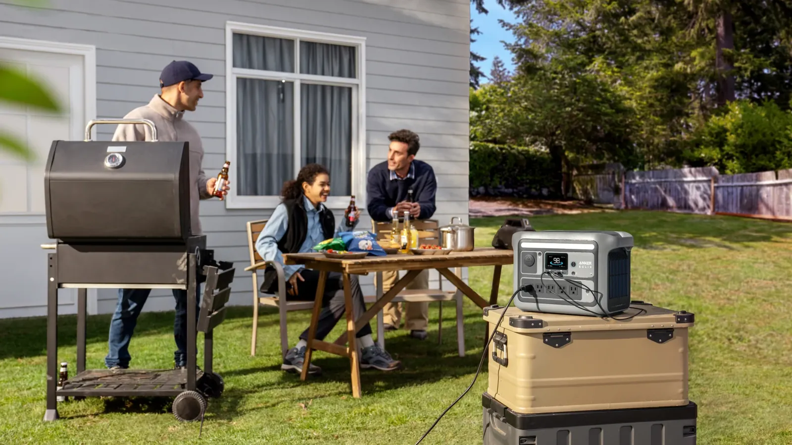 Anker Solix C800 Plus portable power station powering a backyard gathering, front panel with five AC outlets and display visible