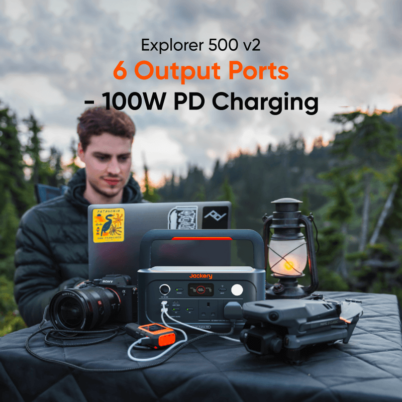 Jackery Explorer 500 v2 at a campsite powering a laptop, camera, drone and lantern through its 6 output ports