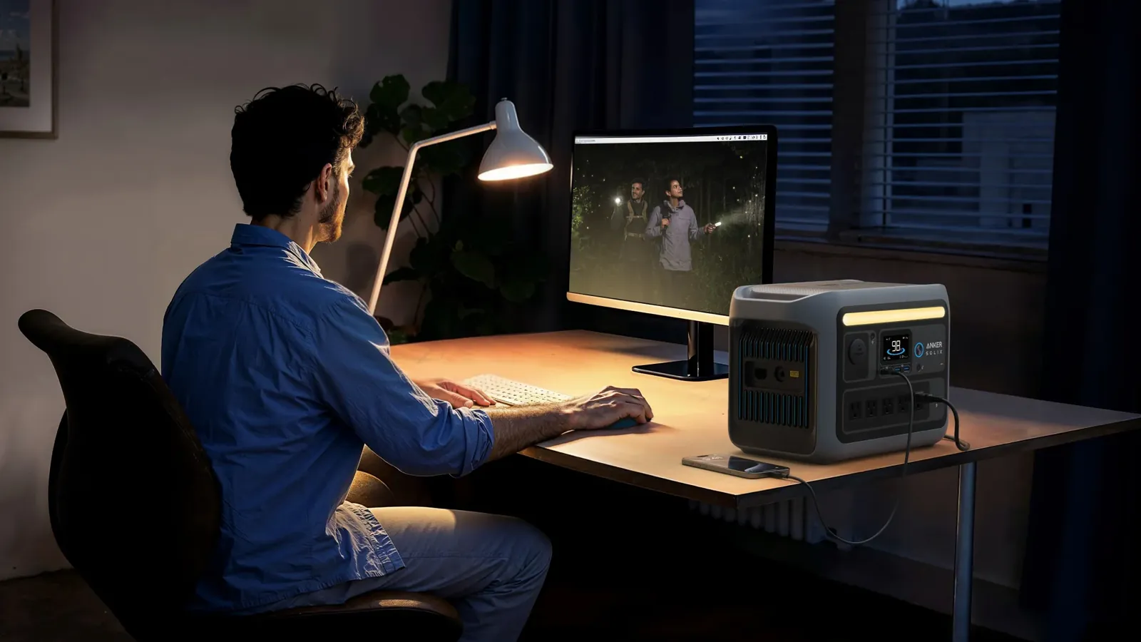 Anker Solix C800 Plus on a desk powering a monitor setup at night, front light bar illuminated